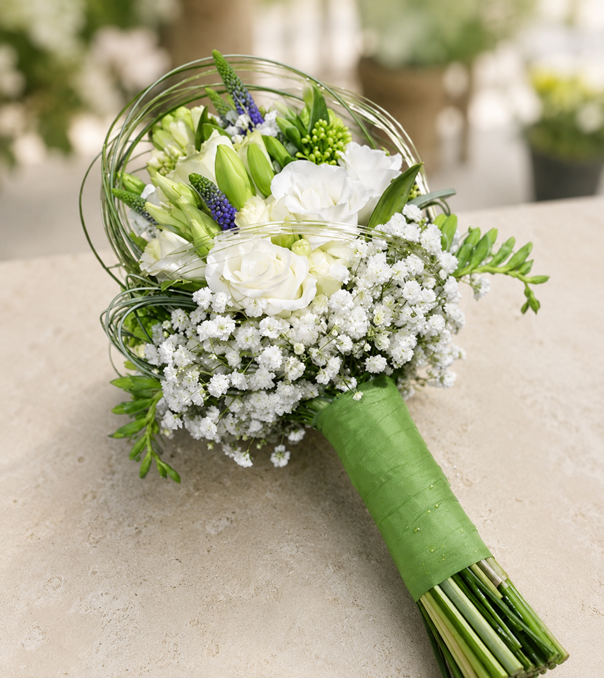 Weiß-grüner Brautstrauß mit weißen Rosen, Schleierkraut, Freesien und grünem Seidenband
