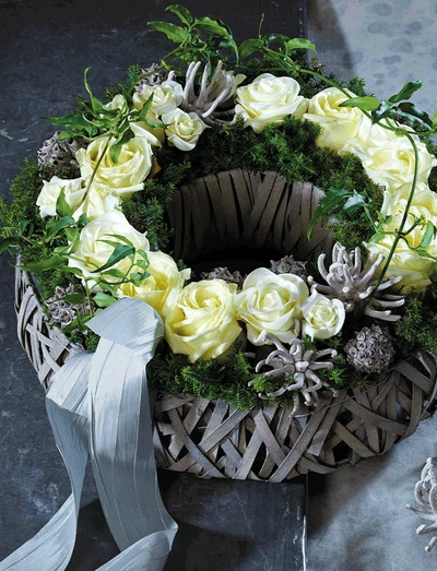 Trauerkranz mit cremefarbenen Rosen, Eukalyptus und grauem Band in handgefertigtem Korb