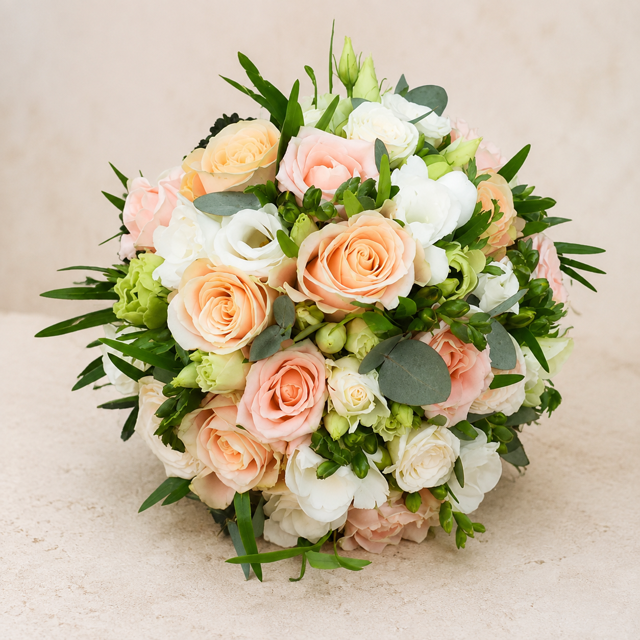 Runder Brautstrauß in Apricot und Creme mit Rosen, Freesien und Eukalyptus